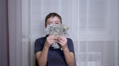 Gülümseyen Çocuk Kol Sandalyesinde otururken 100 Dolarlık banknotlar kazandı.