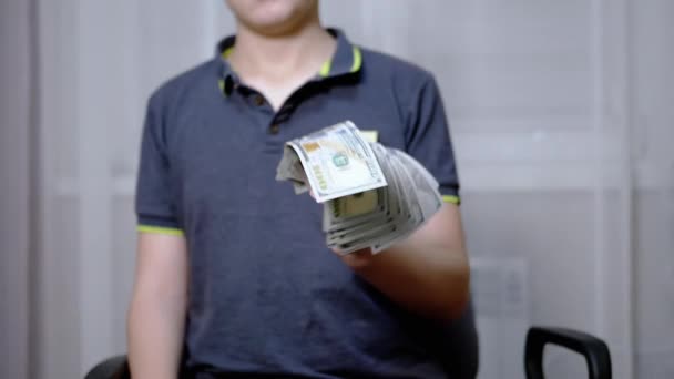 부유 한 어린이 가손에 들고 있는 100 달러짜리 약을 쥐고 흔들고 있다 — 비디오