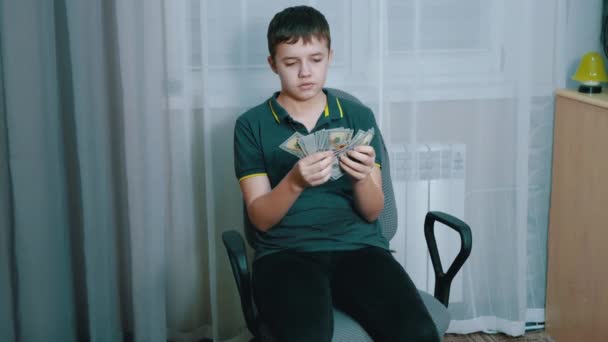 Σοβαρή Teenager Μετρώντας μια στοίβα των 100 δολαρίων νομοσχέδια, ενώ κάθεται σε μια καρέκλα — Αρχείο Βίντεο