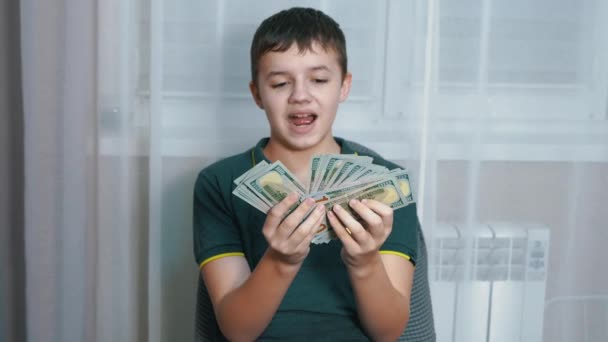 Happy Child trzyma dużo 100 dolarów rachunków w rękach, ściskając je do klatki piersiowej — Wideo stockowe