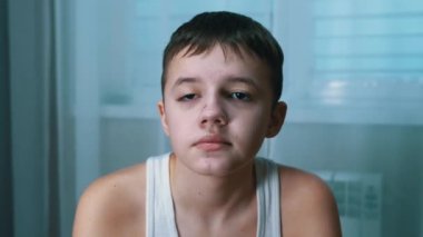 Ciddi bir gencin portresi bir odada oturuyor, uzaklara bakıyor. Ön Görünüm