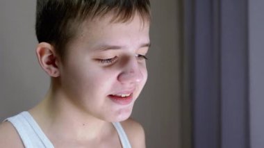 Yakışıklı, gülümseyen, utangaç, uzun kirpikli bir çocuğun portresi.