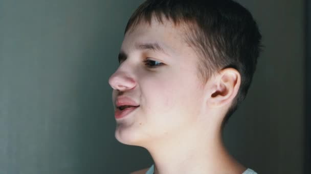 Close-up van een gezichtsprofiel van pratende tiener die naar beneden kijkt. Zijaanzicht — Stockvideo