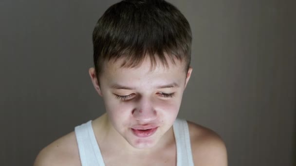 Portret van een gezicht van een pratende tiener die naar beneden kijkt. Vooraanzicht. Sluiten. — Stockvideo