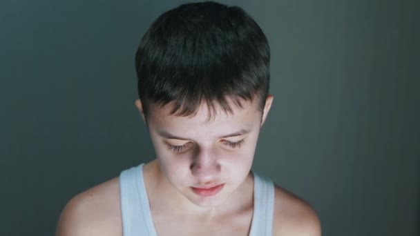 Retrato de un niño culpable y hablador, mirando al suelo con los ojos abatidos. — Vídeo de stock