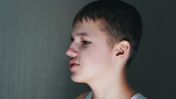 Close-up af en ansigt profil af talende smilende teenager ser ned. Sidevisning – Stock-video