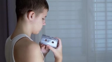 Çocuk Ellerinde Eski Siyah Vintage Ses Kaseti Tutuyor ve Kasedi Geri sarıyor