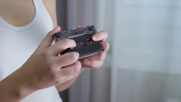 Child Holds an Old Black Vintage Audio Cassette in his Hands, Examines it. 4K — Vídeos de Stock