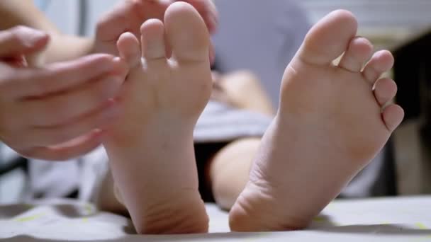 Mãos de massagista Massageie as pernas de uma criança em uma sala de massagem. Fecha. Zoom — Vídeo de Stock