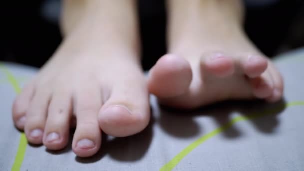 Yakın plan Yorgun Çocuk, odada yatarken ayak parmaklarını oynatıyor. 4K — Stok video