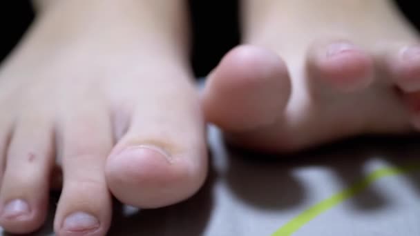 Close-up Tired Child Wiggles his Toes while Lying on the Bed in Room. Zoom — Stock Video