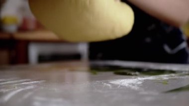 Dişi Eller Maya Hamuru 'nu diz çöktürüp un serpiştiriyor. Ekmek yapmak için sarı, pürüzsüz hamur. Evdeki aile için lezzetli hamur işleri pişiriyorum. Yavaş çekim.