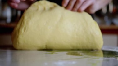 Kadın Elleri Mutfak Masasında Maya Hamuru Dilimliyor. Gevşek, sarı, ekmek ve fırın ürünleri yapmak için pürüzsüz hamur. Ailemiz için lezzetli hamur işleri pişiriyorum. Ağır çekim. Yakın plan..