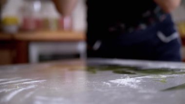 Dişi Eller Maya Hamuru 'nu diz çöktürüp un serpiştiriyor. Ekmek yapmak için sarı, pürüzsüz hamur. Evdeki aile için lezzetli hamur işleri pişiriyorum. Yavaş çekim.