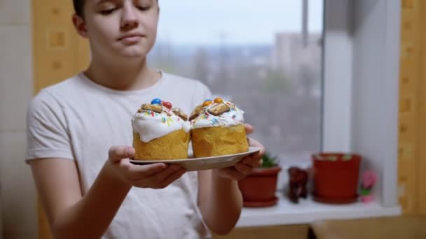 Boy Standing Kitchen Holds Out Two Easter Cakes Plate Close — Vídeo de Stock