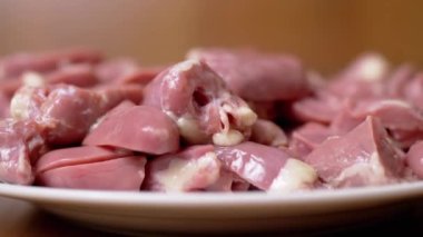 Bir sürü Taze, Soyulmuş, İçi boşaltılmış Çiğ Tavuk Kalpleri, Tabakta Offal Lie. Parlak kırmızı tavuk kalbi, ikiye bölünmüş. Beslenme eti. İkinci sınıfın yan ürünleri. Fakirler için ucuz yemek. Büyüt.