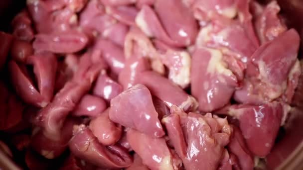 新鮮な皮の多くは 生の鶏の心臓 オファーは プレート上に落ちます 光沢のある赤鶏の心 2つの半分にカットガット 肉料理 2年生の副産物 貧しい人々の食べ物 — ストック動画