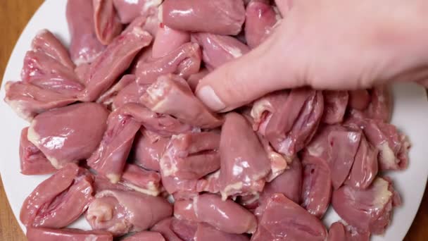 Weibliche Hand Legt Frische Roh Geschälte Hühnerherzen Auf Einen Teller — Stockvideo