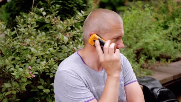 Bald Man Talking Old Push Button Telephone Sitting Bench Park — Stock Video