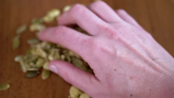 Close Woman Holding Pumpkin Seeds Hand Blurred Table Background Lot — Stock Video