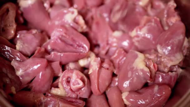 新鮮な皮の多くは 生の鶏の心臓 オファーは プレート上に落ちます 光沢のある赤鶏の心 2つの半分にカットガット 肉料理 2年生の副産物 貧しい人々の食べ物 — ストック動画