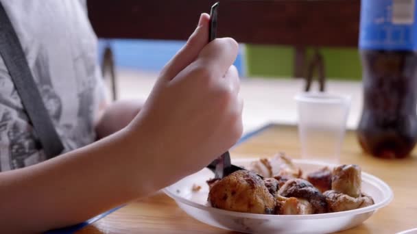 배고픈 아이의 나이프와 돼지고기 스테이크를 튀기고 카페에서 고기를 먹는다 기름진 — 비디오
