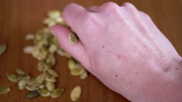 Close Woman Holding Pumpkin Seeds Hand Blurred Table Background Lot — Stock Video