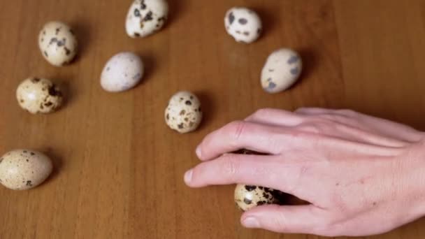 Θηλυκό Χέρι Παίρνει Τρία Αυγά Ορτύκι Από Τραπέζι Τους Εξετάζει — Αρχείο Βίντεο