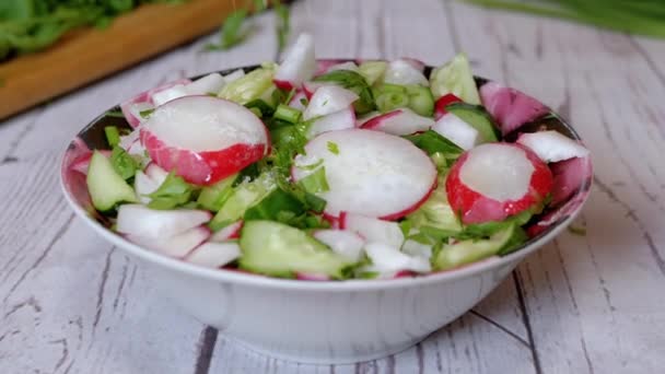 手シェフは大根 キュウリ 緑と野菜サラダに塩を振りかける ズーム 緑のタマネギ パセリ キュウリの野菜 油のカラフルなミックス ベジタリアン 健康食品 — ストック動画