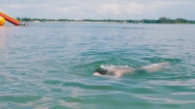Mutlu Çocuk Yüzme, Dalış, Güneş Işıklarıyla Mavi Su Altında Nefes Tutma. Bir çocuk plajda serbest yüzmeyi öğrenir. Spor eğitimi. Sağlığa. Dinlenme, iyileşme, yaz tatili. Yaşam biçimi.