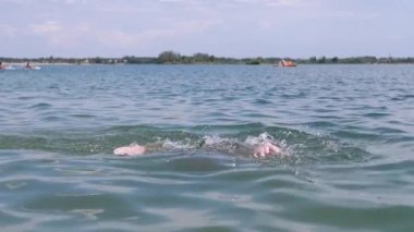 Yüzen, Boğulan, Su Sıçrayan, Sahilde Su Altında Dalan Bir Çocuk. Çocuk elleriyle suyun yüzeyine çarpıyor ve yardım istiyor. Aile tatili, tatil köyü. Tehlike. Hayatta kalmak. Korkudan. Hafta Sonu.