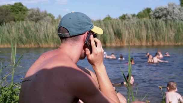 Ukraine Kamenskoe 2022 Male Beach Talking Smartphone Blurred Background River – Stock-video