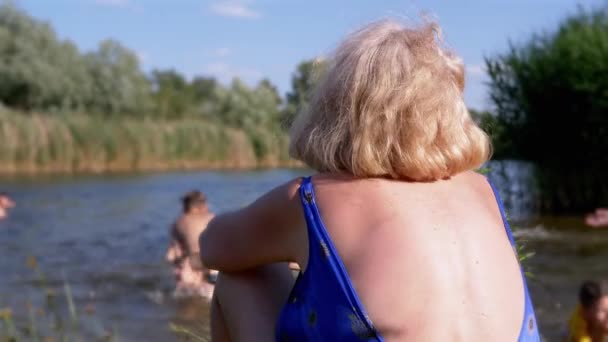 Elderly Woman Beach Bathing Looks Bathing Children River Back View — Stockvideo