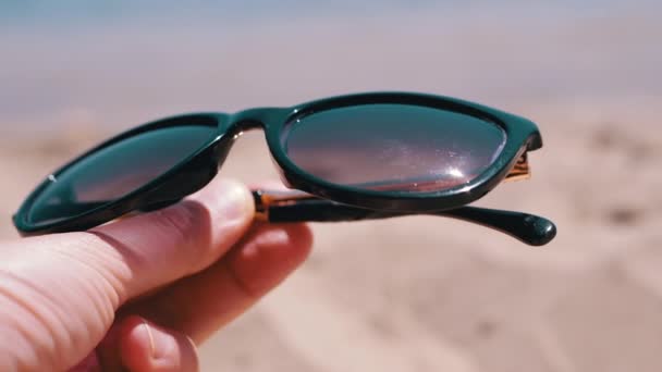 Female Hand Holding Dark Sunglasses Backdrop Seascape Girl Enjoying Relaxing — Stockvideo