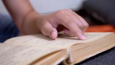 Çocuk, Parmaklarını Kitap ve Okuma Sayfası boyunca hızla koşar. Evde Uzaktan Okuma. Kendini soyutlama. Online eğitim. İnternet olmadan karantinada yeni bilgiler. Metnin bağımsız çalışması. Öğrenme.