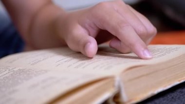 Çocuk, Parmaklarını Kitap ve Okuma Sayfası boyunca hızla koşar. Evde Uzaktan Okuma. Kendini soyutlama. Online eğitim. İnternet olmadan karantinada yeni bilgiler. Metnin bağımsız çalışması. Öğrenme.