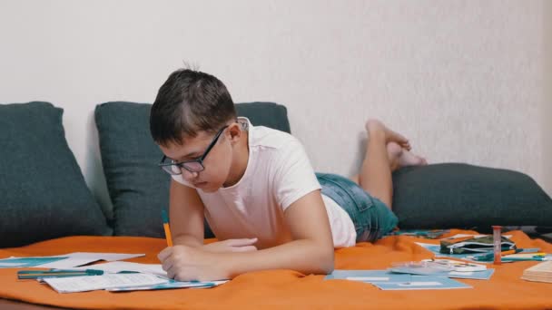 Child Writing Pen Notebook Lying Orange Bedspread Room Serious Sad — Stockvideo