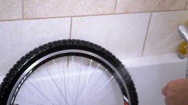 Erkek El Yıkama Kirli Bisiklet Tekerleği Banyodan Suyla Yıkama. Evde bisiklet tekerleklerini yıkıyorum. Topraktan kauçuk temizlemek ve sabunlu köpük kullanmak. Hizmet. Motorsiklet. Dikkat et. Bisikletçi.