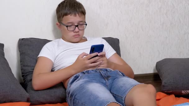 Tired Teenager Glasses Plays Mobile Phone While Lying Pillow Room — Stock Video