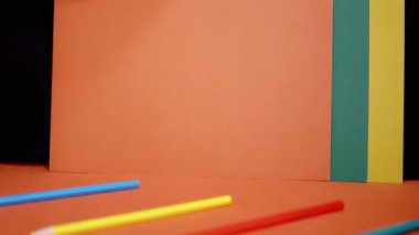 Bright Saturated Multicolor Background of Colored Paper, Cardboard. Showing green orange blue, yellow, white, black, red colors, pencils. Learning colors, shapes for preschool kids. Rainbow School.