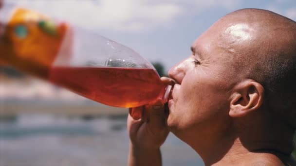 Bald Wrinkly Man Greedily Drinks Juice Drink Colored Water Sky — Stockvideo