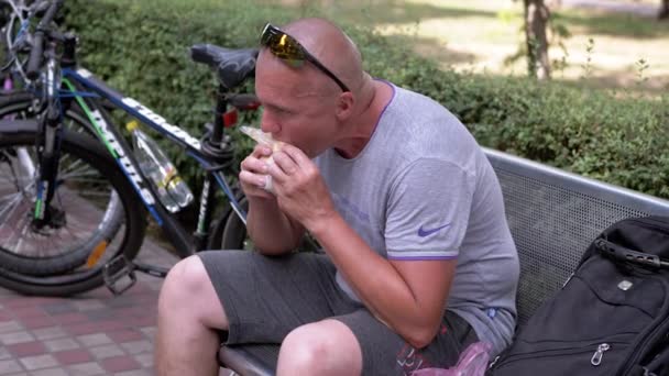 Ukraine Kamenskoe 2022 Hungry Cyclist Sitting Bench Eating Pita Bread — Wideo stockowe