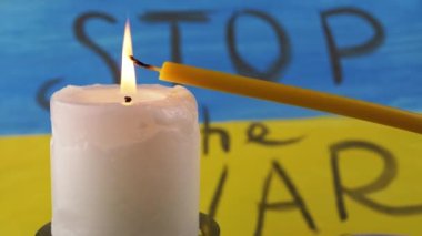 Two Burning Candles on the Background of the Yellow Blue Flag of Ukraine. Prayer. Inscription Stop the war on national flag, poster. Drawing. Memory of the victims of the war, died soldiers in battle.
