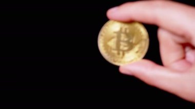 Hand Businessman Holding One Gold Bitcoin Coin on Isolated Black Background. Digital symbol of a virtual currency, money. BTC. Exchange market, digital investment. Cryptocurrency. Capital. Wealth.