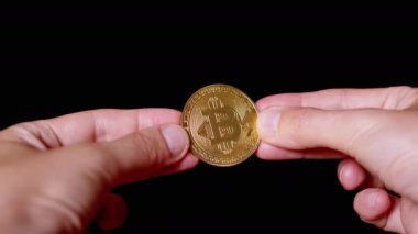 Businessman Hands Holding One Gold Bitcoin Coin on Isolated Black Background. Digital symbol of a virtual currency, money. BTC. Exchange market, digital investment. Cryptocurrency. Capital. Wealth.