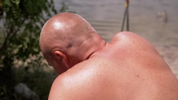 晒黑的肩膀 一个秃头的男人后面休息的自然 后视镜闷闷不乐 晒黑了的家伙与雀斑 摩尔背面从灼热的太阳 炎热的天气 夏天的时间 — 图库视频影像