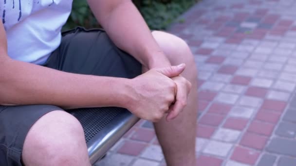 Male Rubbing Hands Sitting Bench Urban Park Moment Waiting Excitement — Stock Video