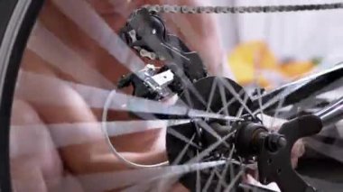 Close-up Rotation of a Bicycle Wheel, Pedals, Chain. Six-speed gearbox. Master checks transport before the trip. Movement of gear on a chain. Bicycle repair at home. Test, restoration, mending.