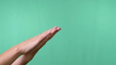 Boş Yeşil Krom Anahtar Arkaplanına Elleri Sürten Kadın. Bekleme anı, el masajı, ısınma, cilt okşama, el yıkama. El hareketleriyle. Uzay reklam arkaplanını kopyala. Yakın plan..