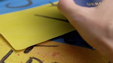 Ukrayna Bayrağı 'nın Arkaplanına Biyometrik Pasaportu Yerleştirdi. Üzerinde yazı olan sarı, mavi Ukrayna bayrağı çizildiğinde savaş sona eriyor. Savaş, göçmenler, Rus saldırısı.